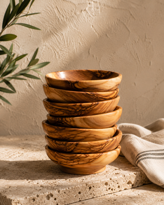 Stack of wooden bowls on a stone surface with a beige background