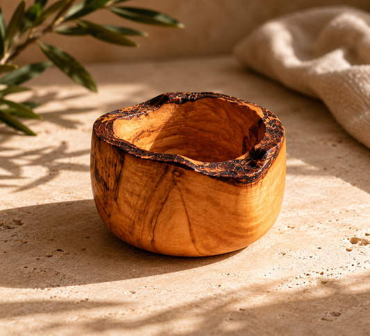 Wooden bowl on a textured surface with a plant in the background