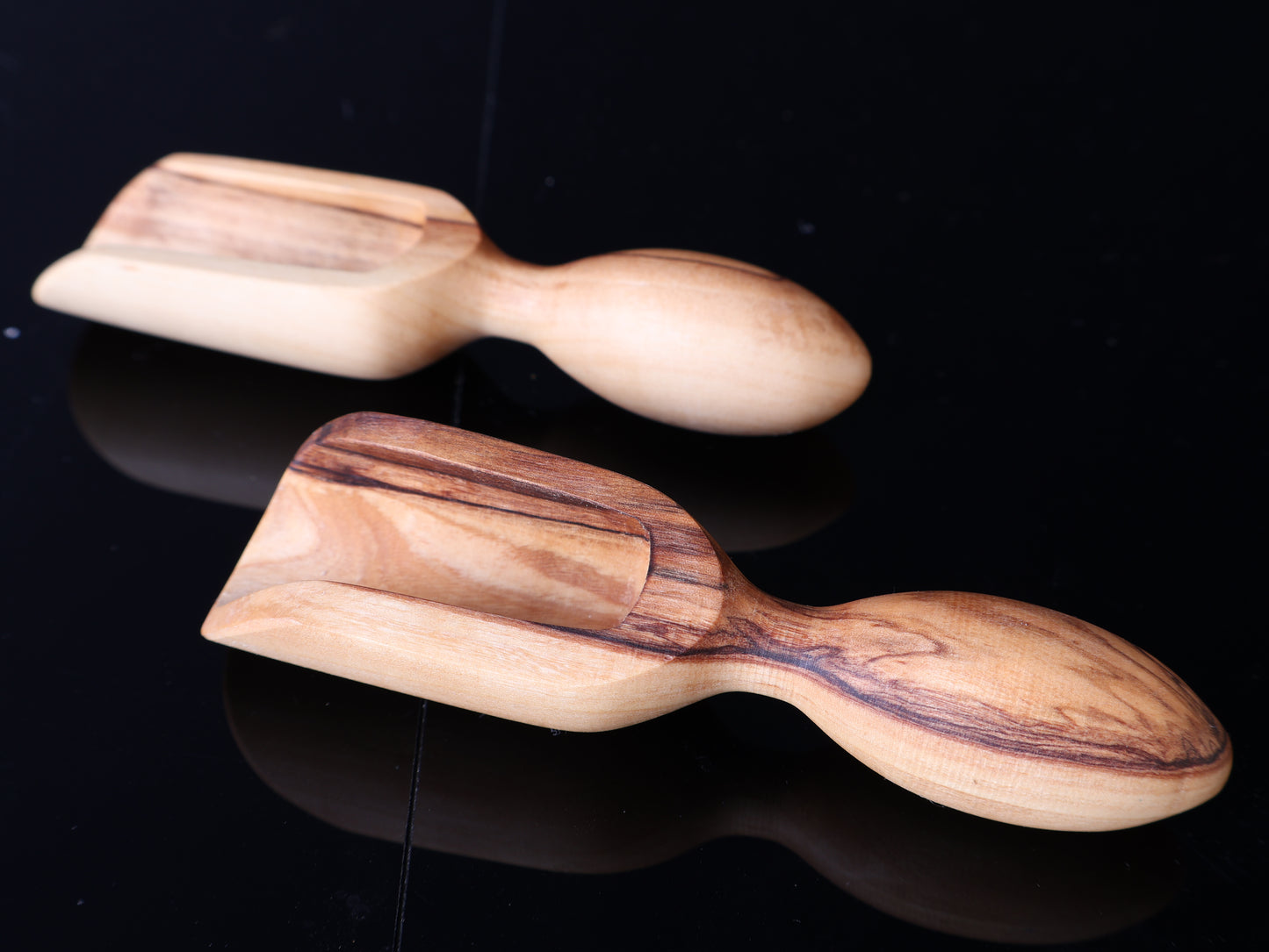 Two wooden massage tools on a black background