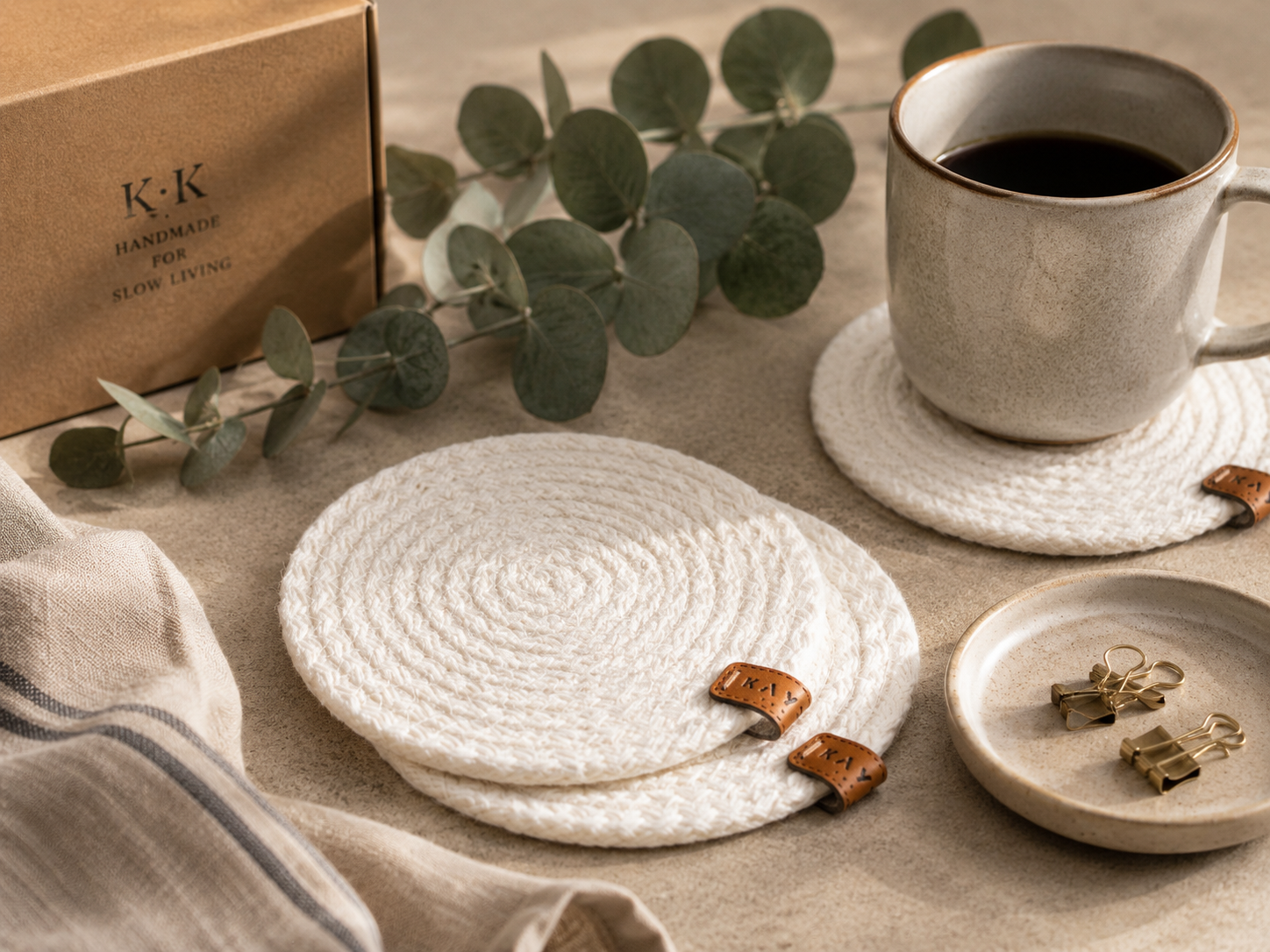 White woven coasters on a table with a cup of coffee and decorative elements.
